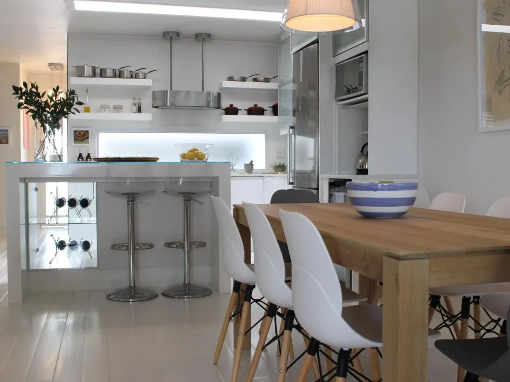 Modern open-plan kitchen with white cabinetry and dining area visible