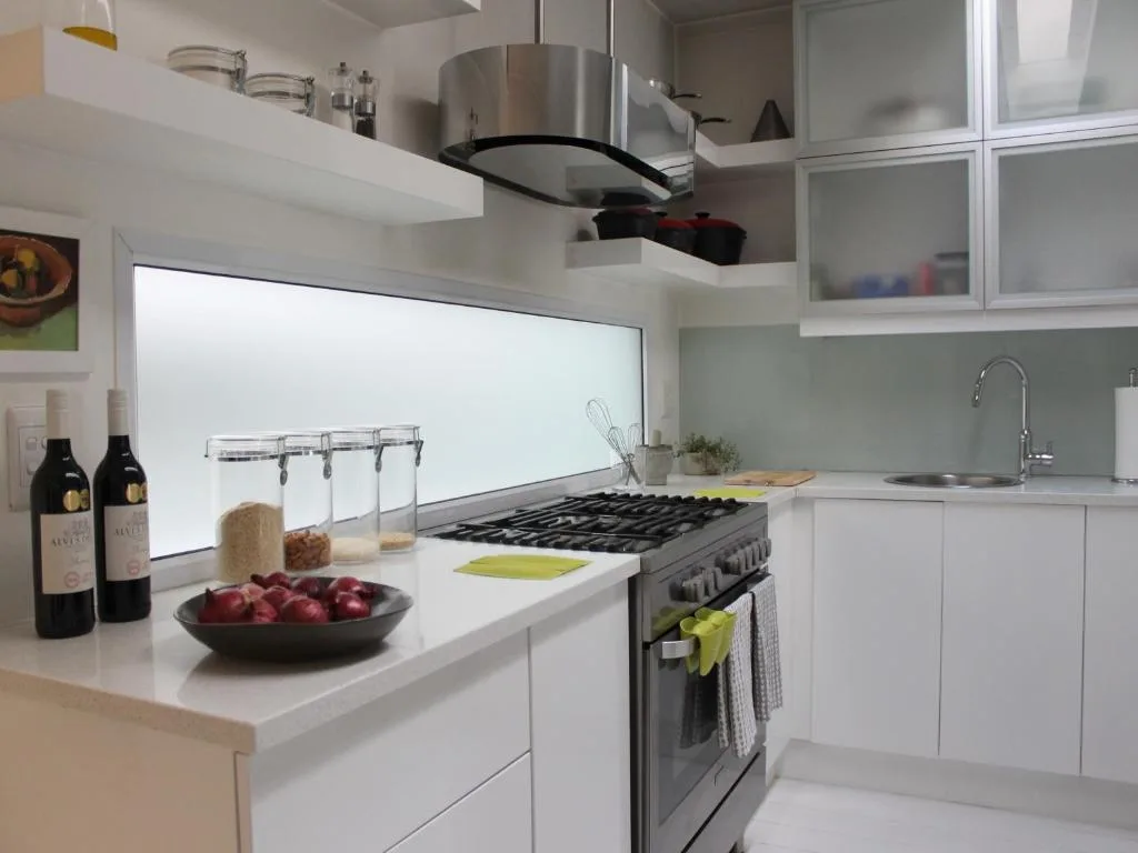 Modern kitchen with gas stove, white cabinetry, and fresh produce on counter