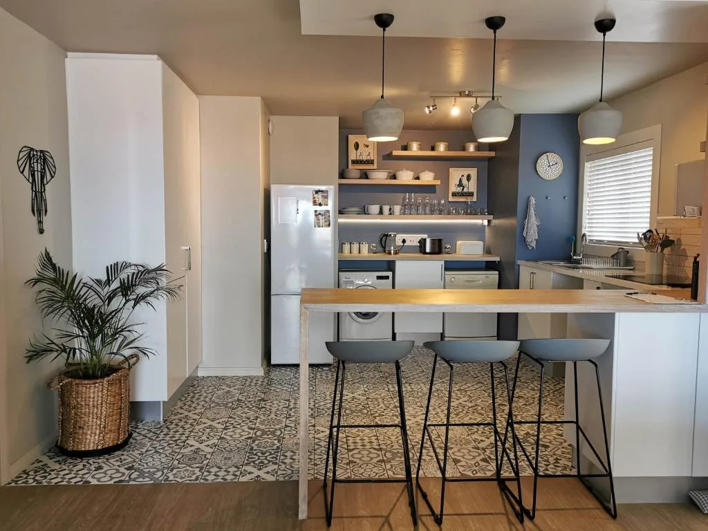 Modern kitchen with island seating, open shelving, and stainless appliances