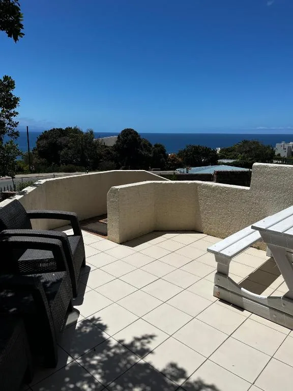 Spacious tiled deck with ocean views, seating area, and coastal landscape