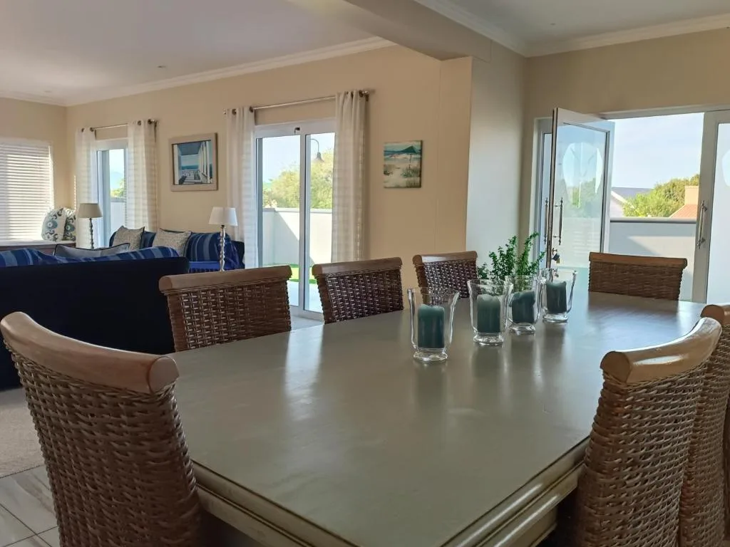 Spacious dining area with woven chairs and modern table overlooking garden