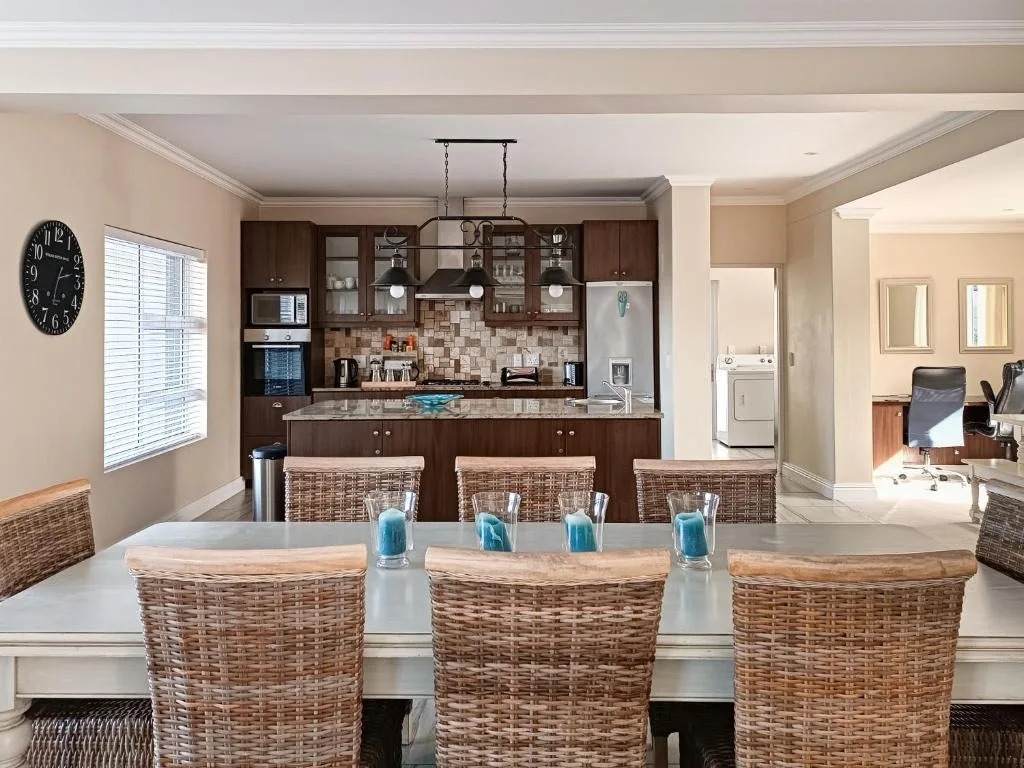Modern kitchen with dark cabinetry, island counter, and tiled backsplash