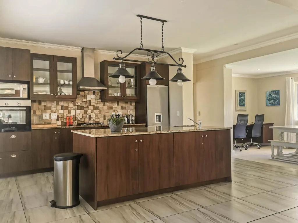 Modern kitchen with dark wood cabinetry, granite countertops, and pendant lighting