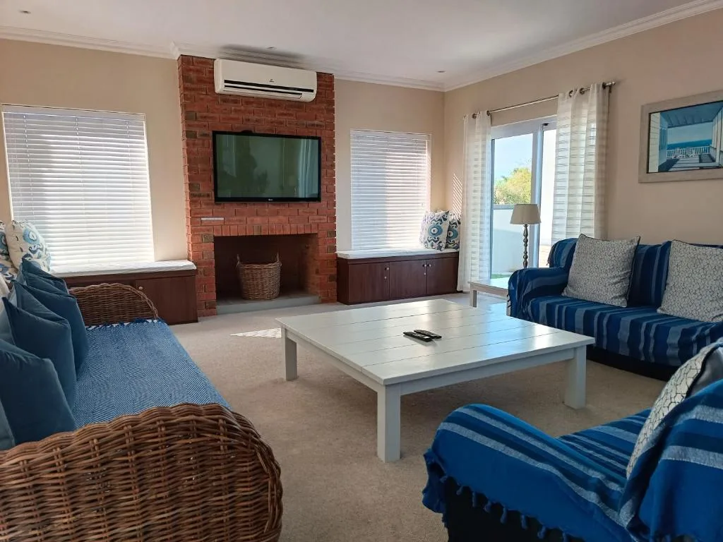 Spacious living room with blue striped sofas, white coffee table, and fireplace