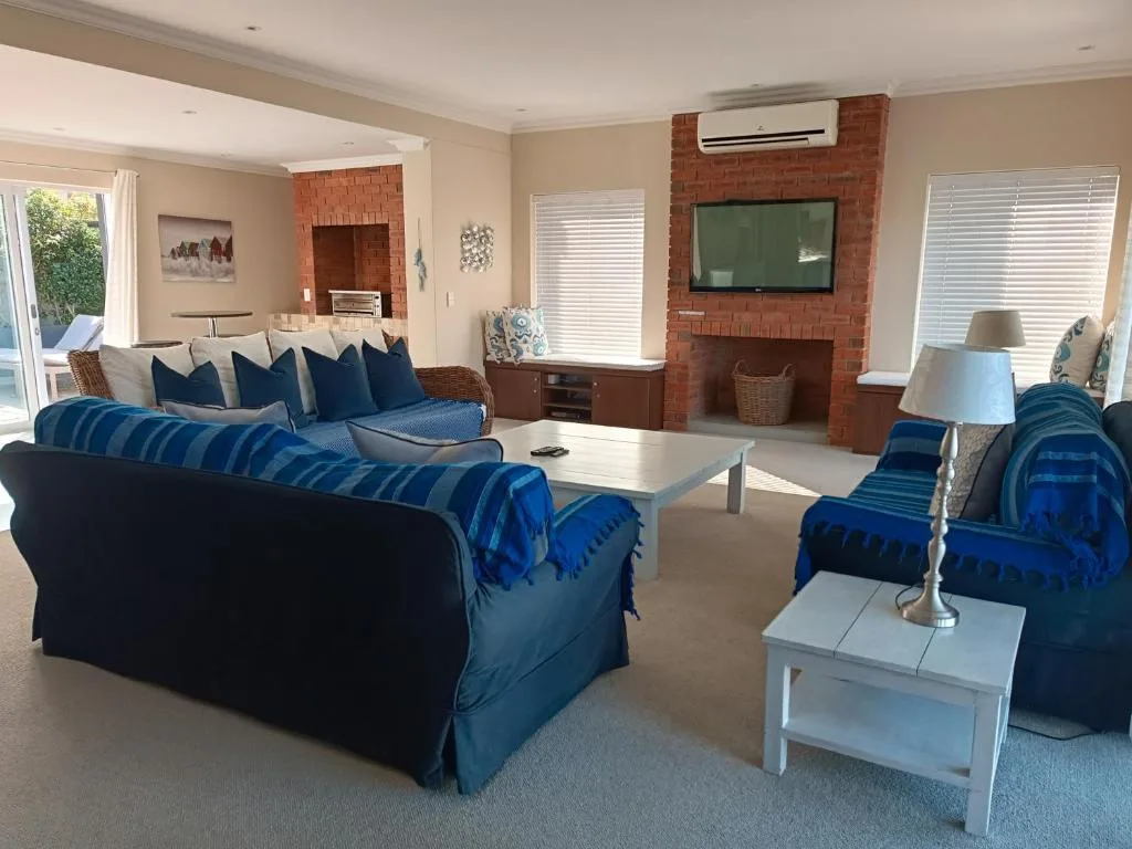 Spacious lounge with blue sofas, fireplace, and flat-screen TV