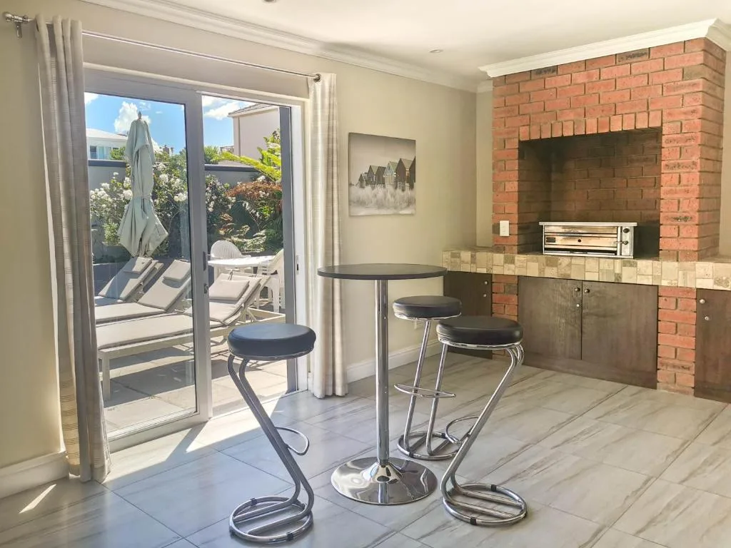 Modern lounge area with bar seating and brick fireplace overlooking deck