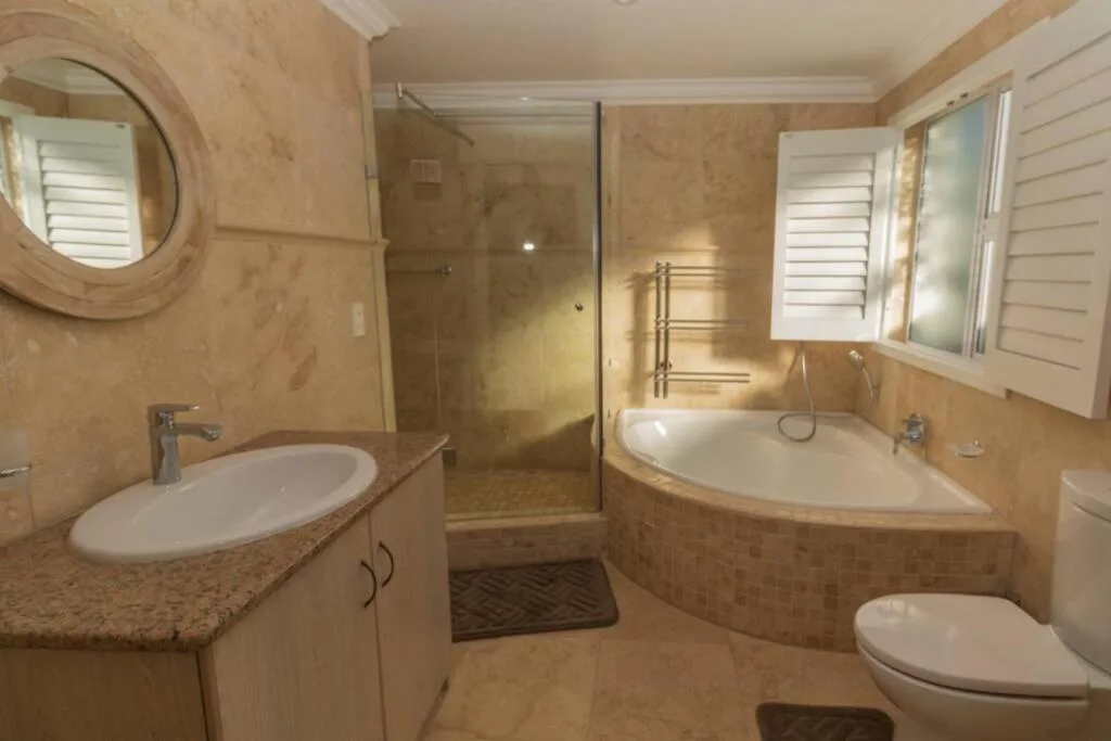 Spacious bathroom with corner tub, walk-in shower, and dual vanity sink