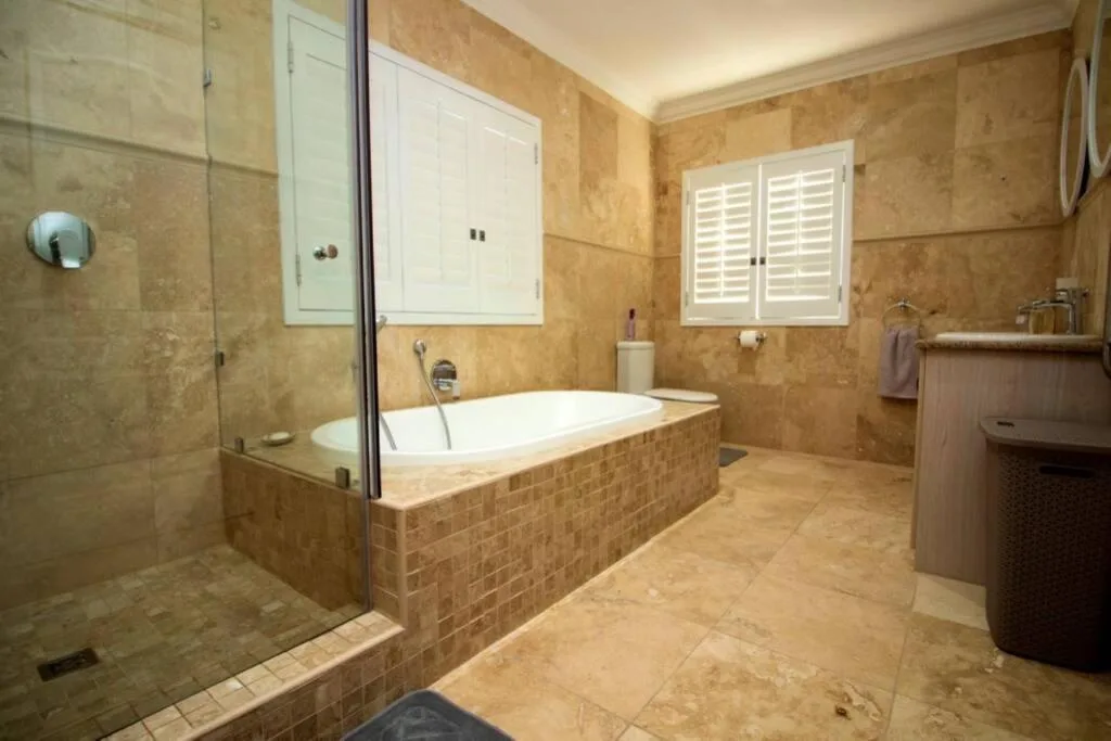 Spacious bathroom with soaking tub, walk-in shower, and neutral tile finishes