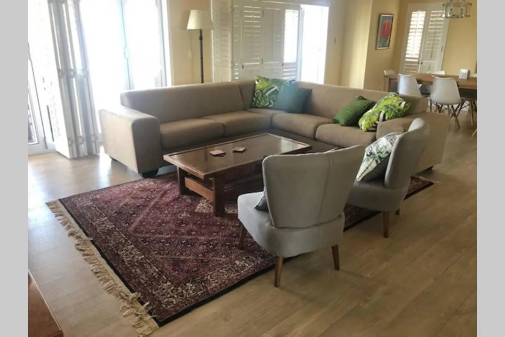 Spacious living room with gray sectional sofa and armchairs around wooden table