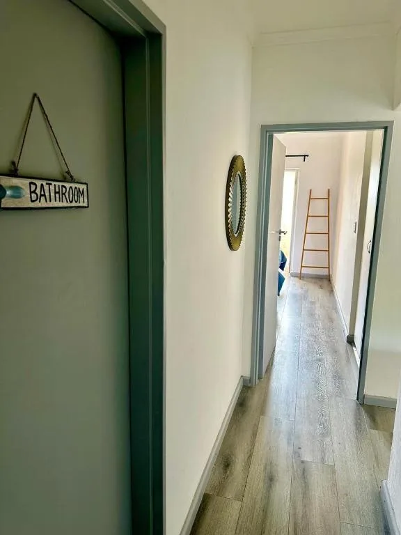 Hallway with green doorframe and bathroom sign directing guests