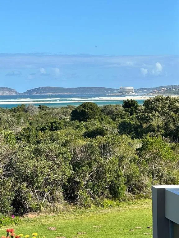 Turquoise lagoon and sandy beach visible from property with coastal hills beyond