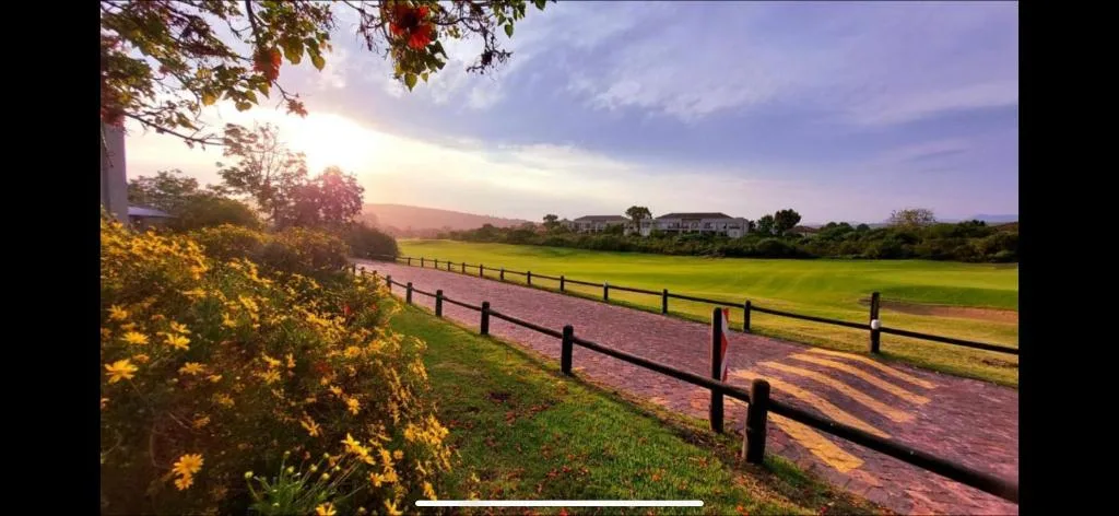 Scenic sunset view over rolling green fields and distant mountains from property