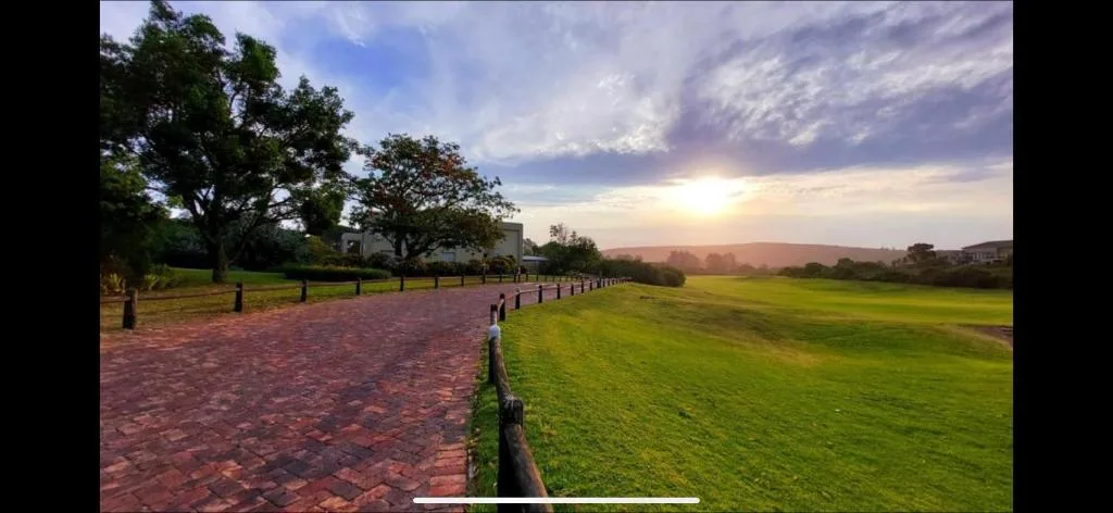 Scenic sunset view over expansive manicured gardens and surrounding countryside landscape