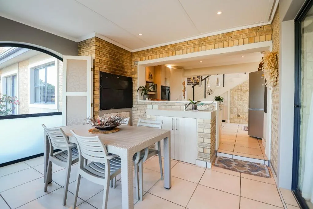 Dining area with table, chairs, and open-plan kitchen visible beyond
