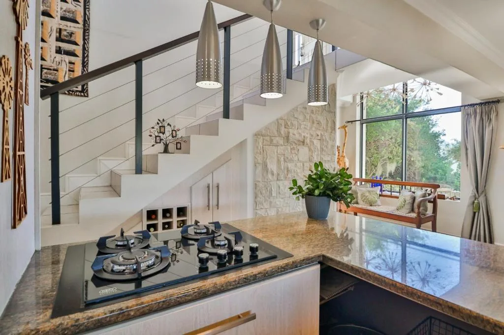 Modern kitchen with gas cooktop, granite counters, and pendant lighting