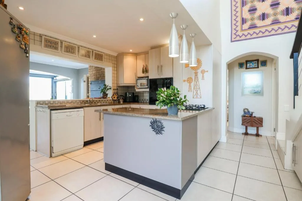Modern kitchen with island, stove, and pendant lighting fixtures