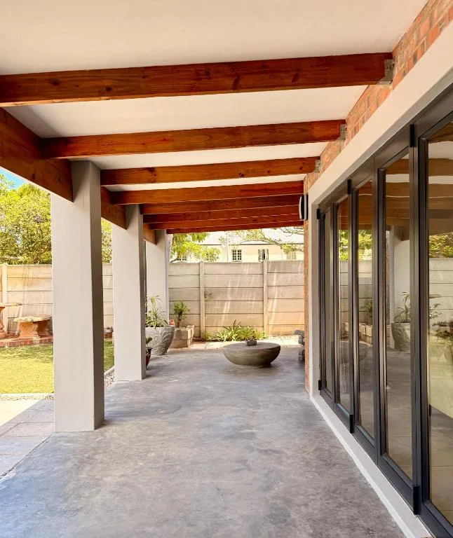 Covered patio with wooden beams and large sliding glass doors