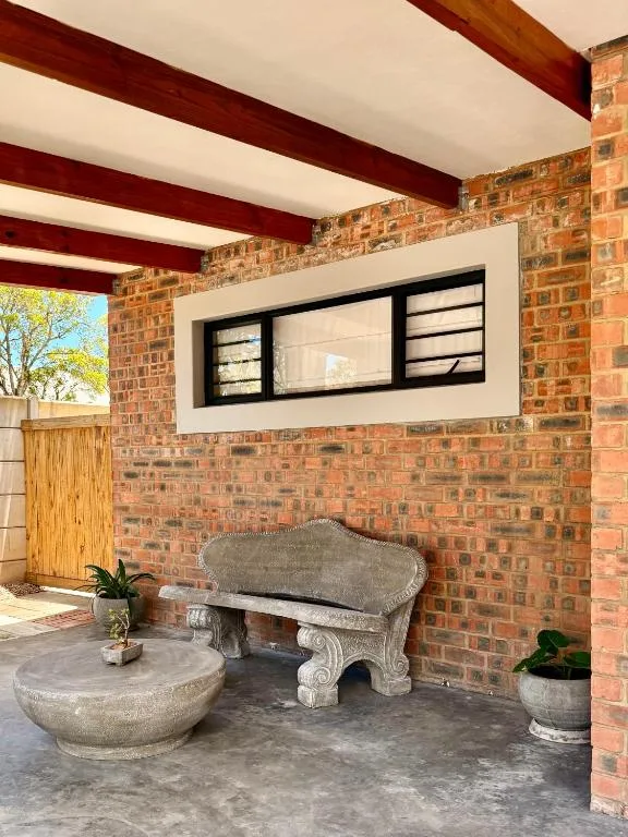 Covered outdoor patio with ornate stone bench and brick walls