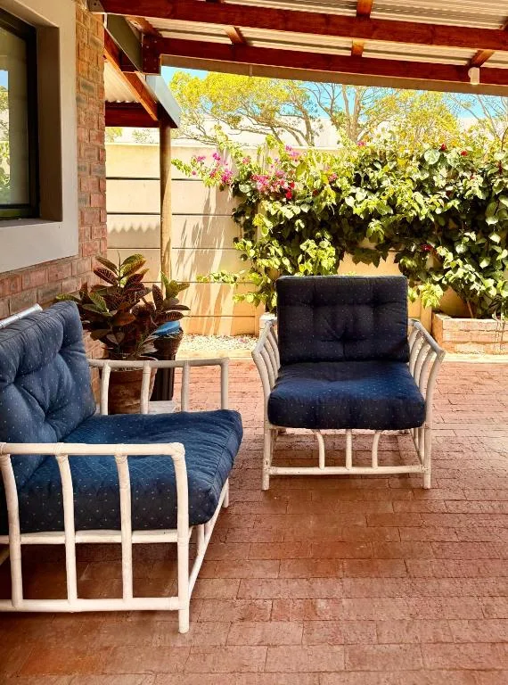 Covered patio with comfortable seating and lush garden views