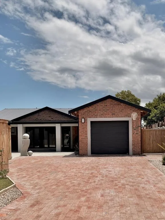 Modern brick holiday home with garage and paved driveway entrance