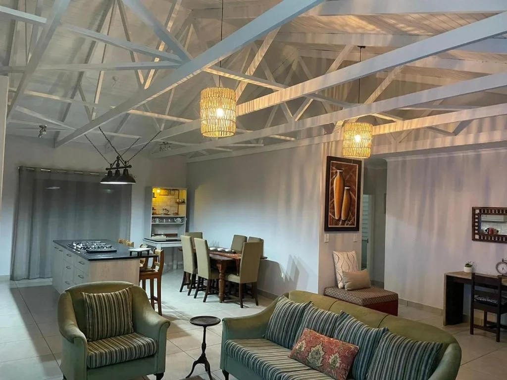 Open-plan lounge with striped armchairs, exposed beam ceiling, and pendant lighting