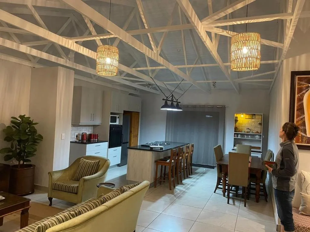 Open-plan lounge and dining area with cream furnishings and exposed beams