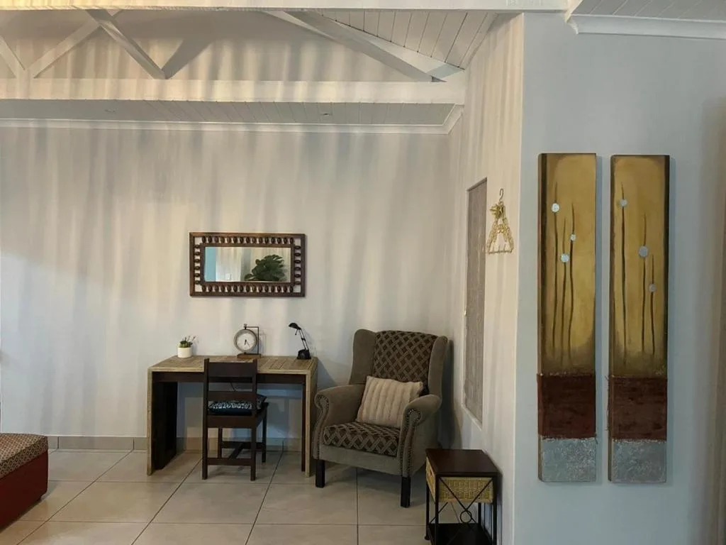 Bright lounge with armchair, desk, and decorative wall art