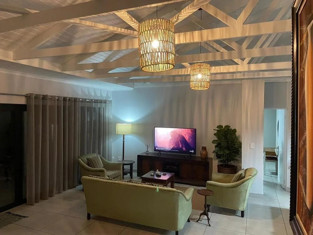 Modern lounge with cream sofas, TV unit, and woven pendant lights