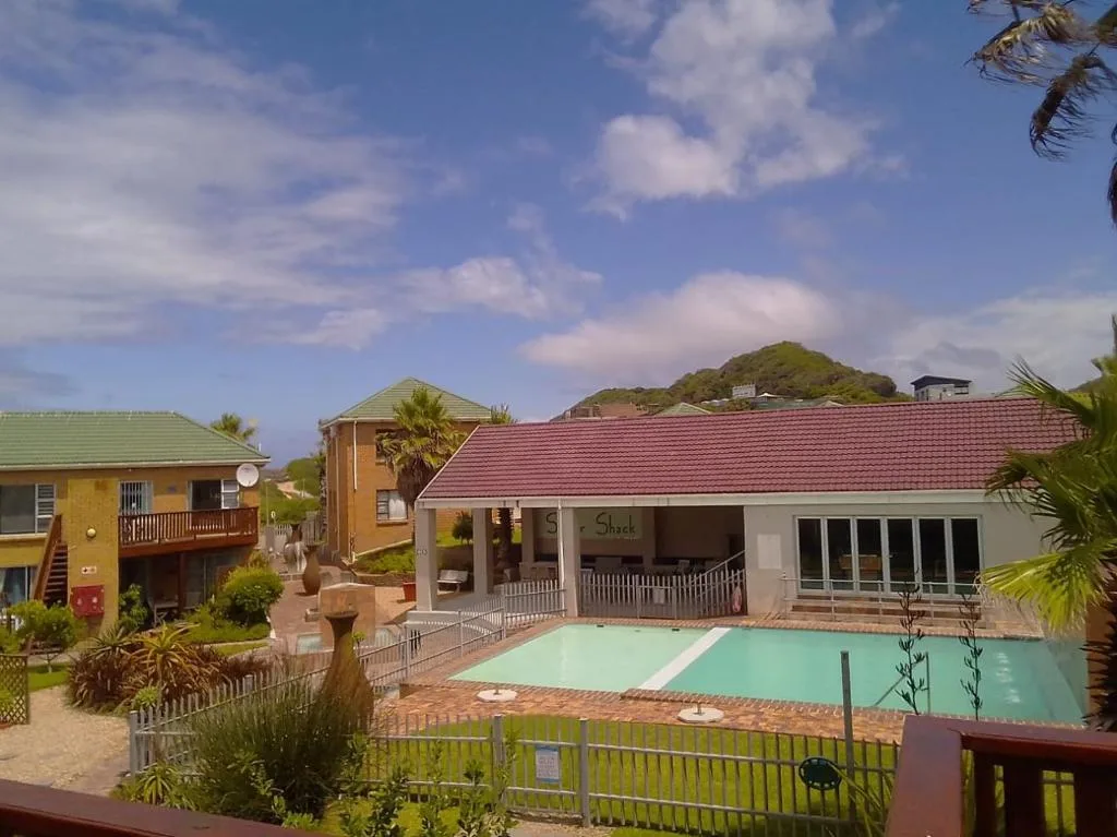 Turquoise swimming pool with white lane markers and red-roofed building
