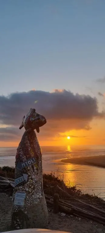 Golden sunset over calm water with iconic coastal landmark in foreground