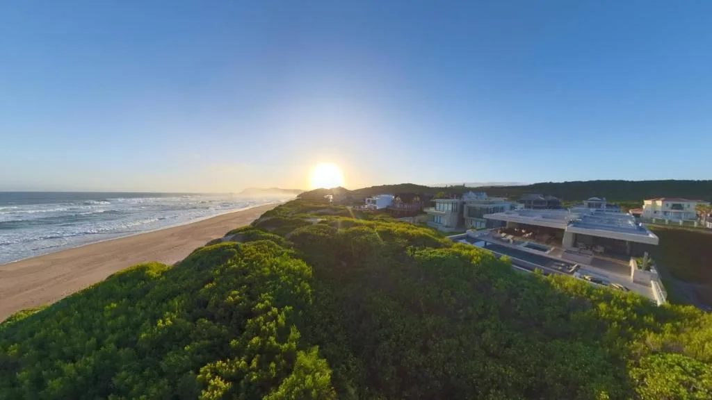 Coastal sunset view of beachfront properties nestled among coastal vegetation
