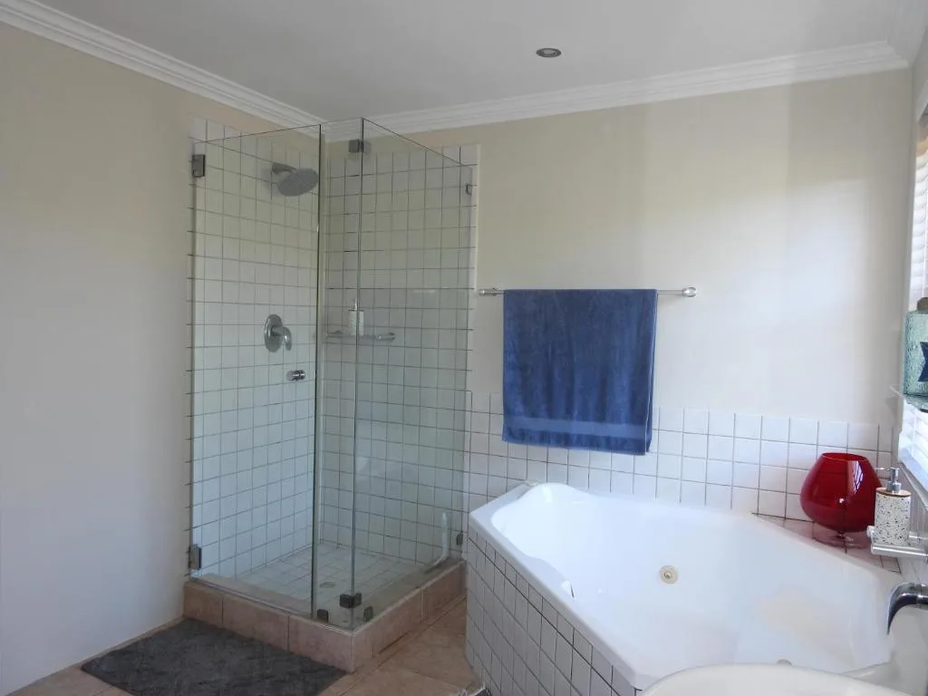 Modern bathroom with glass shower enclosure and white bathtub