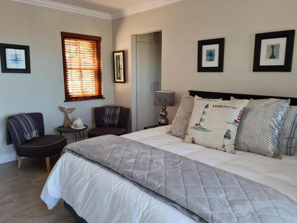 Spacious bedroom with queen bed, comfortable seating area, and coastal decor