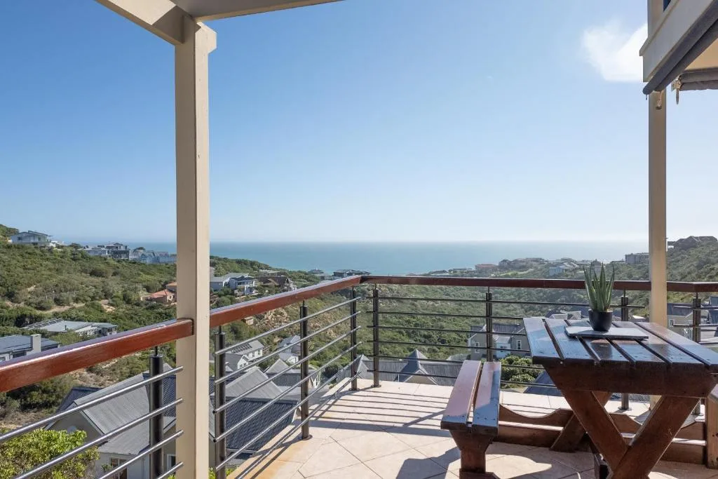 Elevated deck with ocean views, wooden railings, and coastal landscape