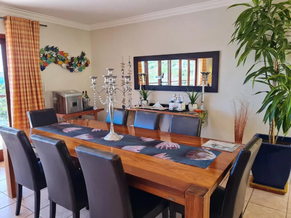 Elegant wooden dining table with black leather chairs and decorative candelabra