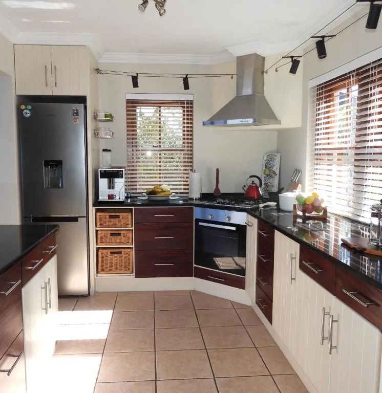 Modern kitchen with cream cabinets, dark wood drawers, stainless steel appliances