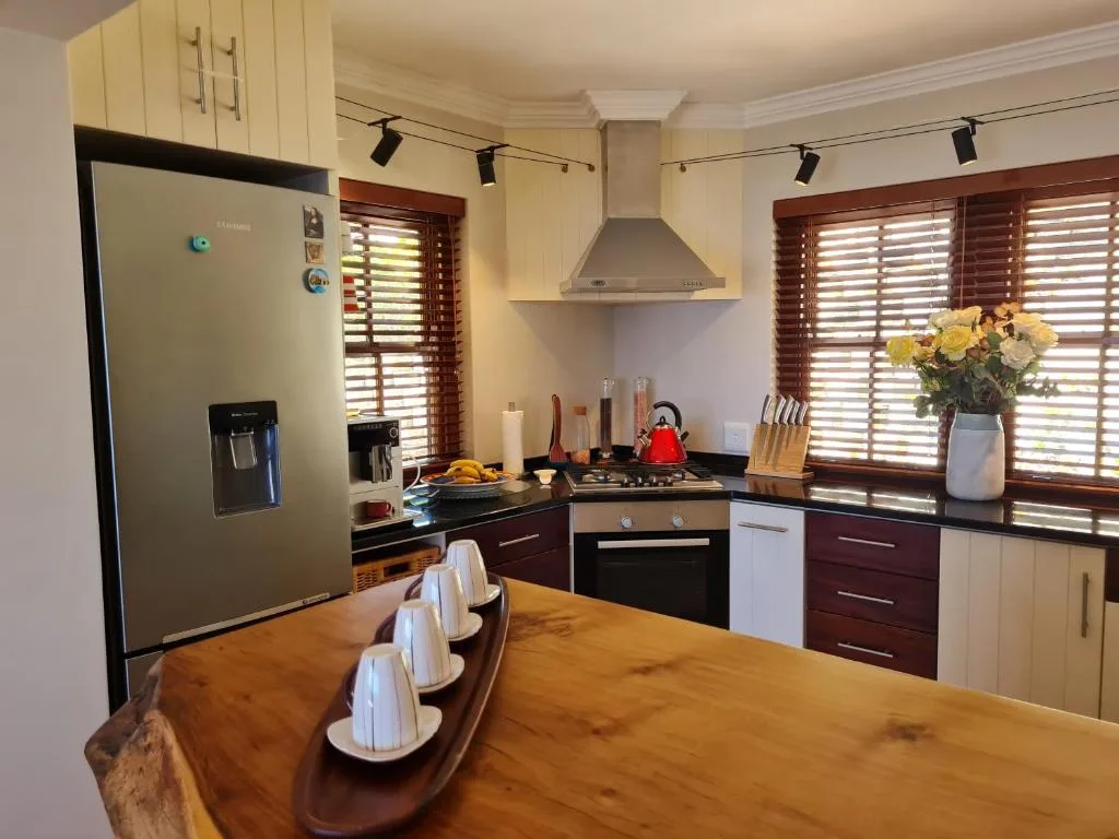 Modern kitchen with cream cabinetry, stainless steel appliances, and wooden countertop island