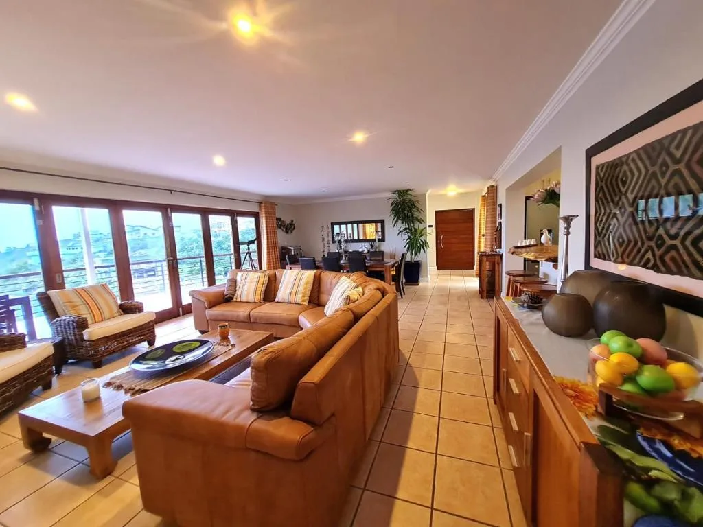 Spacious lounge with tan leather seating and scenic ocean views through large windows