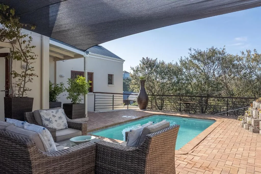Turquoise swimming pool with lounge seating and mountain views