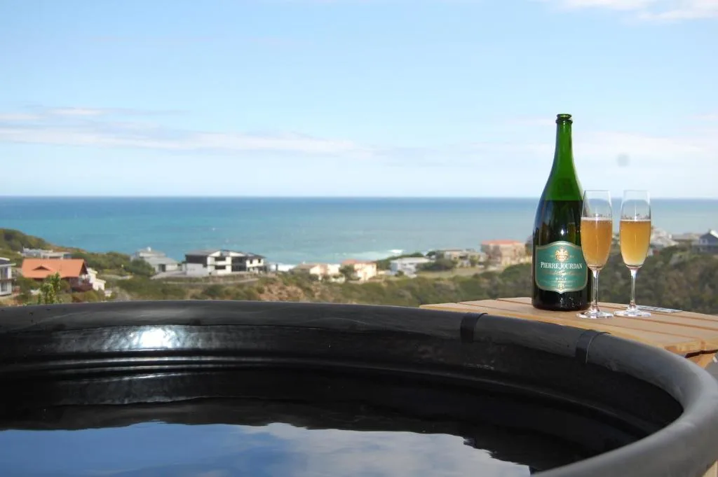 Ocean and coastal landscape vista with wine and glasses on deck