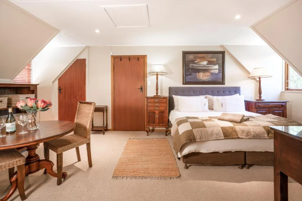 Spacious bedroom with queen bed, wooden furniture, and natural light