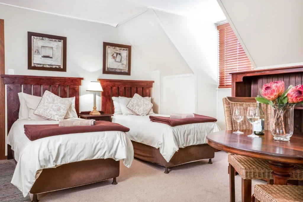 Twin bedroom with wooden headboards, white linens, and burgundy accents