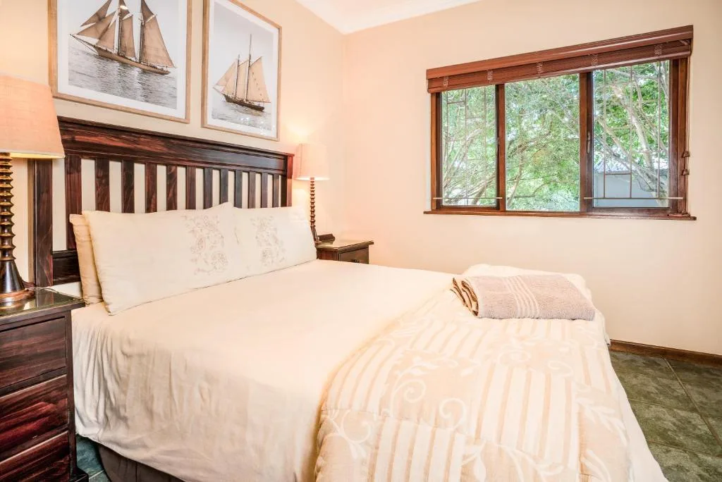 Spacious bedroom with wooden bed frame and ocean view windows