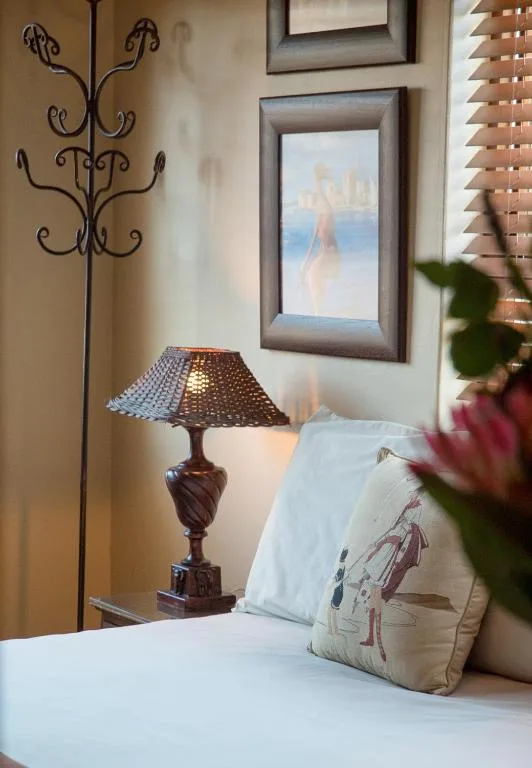 Bedroom with bed, decorative lamp, framed artwork, and coastal view