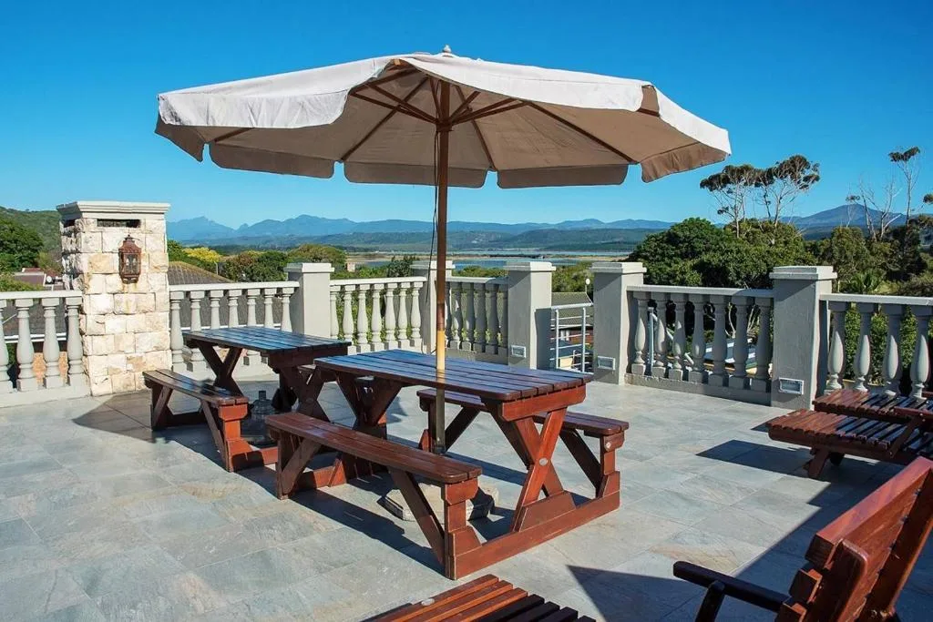 Outdoor patio with picnic tables, umbrella, and mountain lagoon views