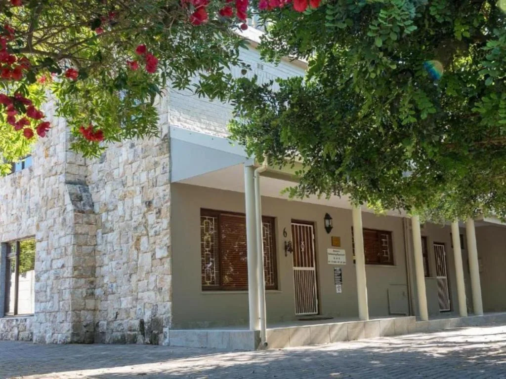 Stone and cream facade with flowering vines overhead, modern entrance
