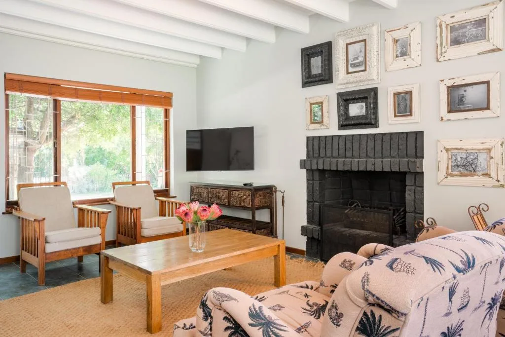 Bright lounge with fireplace, wooden furniture, and framed artwork on walls