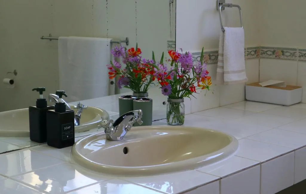 Modern bathroom vanity with dual sinks, colorful fresh flowers in vase