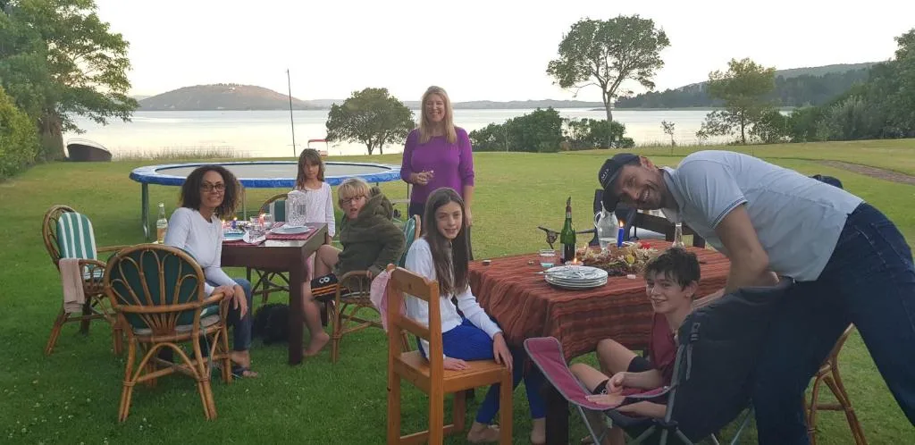 Outdoor lakeside gathering with tables, chairs, and scenic water views