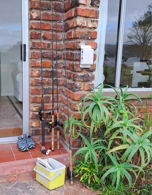 Entrance corner showing red brick column, plant, and outdoor amenities